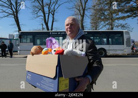 19 mars 2022, Siret, Roumanie : un homme porte une boîte avec des jouets, il est un volontaire venu à la frontière. Environ 3 mille personnes arrivent quotidiennement à Siret, en Roumanie, pour se réfugier contre la violence causée par la guerre entre la Russie et l'Ukraine. Dans cette ville frontalière, un couloir d'aide humanitaire a été organisé entre diverses organisations civiles et étatiques. Les personnes qui fuient l'Ukraine sont principalement des femmes, des enfants et des adultes plus âgés. Lorsqu'ils franchissent la frontière, les gens reçoivent de l'aide médicale, psychologique, alimentaire, de transport et d'hébergement. Grâce à l'aide des bénévoles, ces personnes peuvent faire une pause Banque D'Images