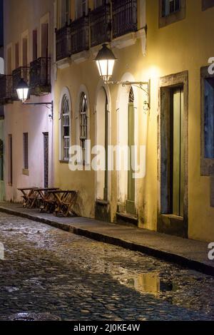 Vieille rue pavée avec maisons coloniales éclairées par une lanterne la nuit Banque D'Images