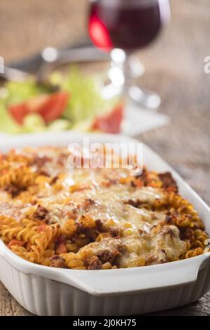 Pâtes au gratin avec salade sur bois Banque D'Images