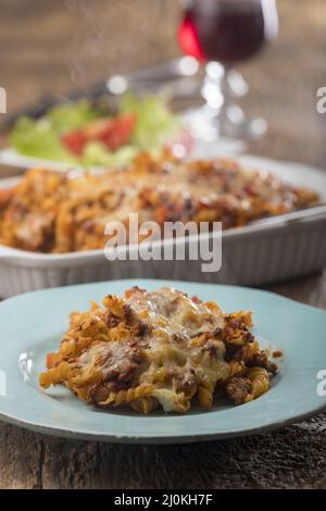 Pâtes au gratin avec salade sur bois Banque D'Images