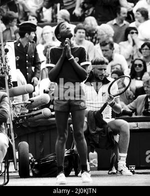 Le joueur suédois de tennis Bjorn Borg s'assoit entre les matchs lors de son match semi final de Mens Singles contre Jimmy Connors sur Center court, Wimbledon.debout devant lui est un garçon de balle qui semble prier. 2nd juillet 1981. Banque D'Images