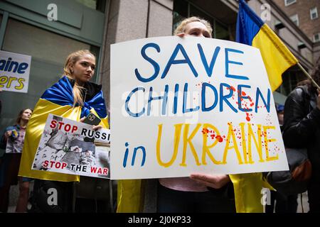 New York, États-Unis. 19th mars 2022. Un manifestant tient un panneau disant, « Save Children in Ukraine » pendant le rallye. Les manifestants américano-ukrainiens défilent du bâtiment de l'UNICEF à Times Square en solidarité avec les mères ukrainiennes et appellent à sauver leurs enfants de l'agression militaire russe. Crédit : SOPA Images Limited/Alamy Live News Banque D'Images