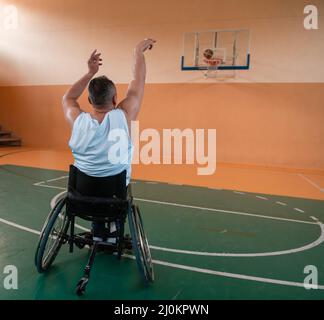 Un caméraman équipé d'un équipement professionnel enregistre un match de l'équipe nationale en fauteuil roulant jouant un match dans l'arène Banque D'Images