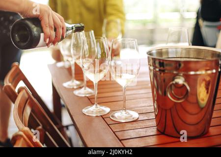 Verres avec différents types de vin et mains humaines tenant des verres à vin en arrière-plan Banque D'Images