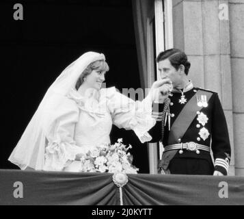 **VERSION COURTE - CADRE ORIGINAL LARGE AUSSI DANS CET ENSEMBLE*** le prince Charles embrassa la main de sa mariée, Lady Diana Spencer. Photo du couple heureux sur le balcon de Buckingham Palace après la cérémonie de mariage. Photo prise le 29th juillet 1981. Banque D'Images