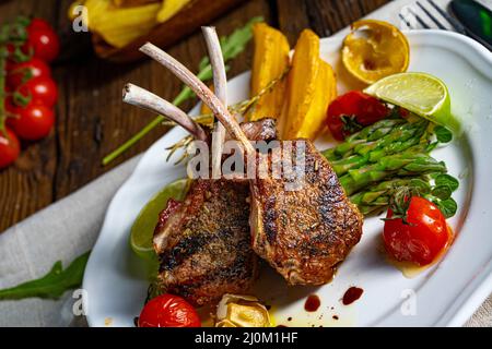 Côtelettes d'agneau marinées dans des herbes aux asperges vertes et au citron vert Banque D'Images