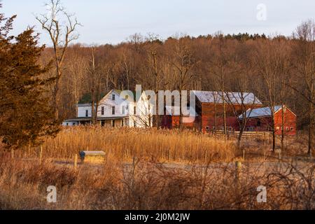 Grande maison de campagne rurale et grange rouge dans un paysage sec d'hiver Banque D'Images