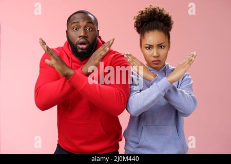 Sérieux-regardant nerveux paniquant deux afro-américains gars fille montrant crossstop gesture homme se sentent choqués demander non d Banque D'Images