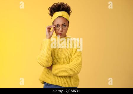 Suspect strict sérieux-look attrayant astucieux afro-américain femme chèque verre smirking désapprobation frowning Banque D'Images