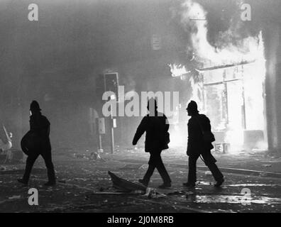 Toxteth Riot 6th juillet 1981Police des officiers en train d'émeutes à l'extérieur d'une boutique incendiée pillée de Park Road. Les émeutes ont été déclenchée à la suite de l'interception par la police des motocyclistes Leroy Cooper, dans la rue Selbourne. Une foule s'est rassemblée, les noms se sont multipliés par des plaisanteries et en quelques minutes, il y avait une fracture à grande échelle qui a vu trois policiers blesser et un jeune homme local, arrêté pour voies de fait. Cela ne s'est pas arrêté là. La police a monté des patrouilles supplémentaires dans la région et tôt le soir suivant, le 4 juillet, ils ont été attaqués par une foule armée de briques et de bombes à essence. Le fusible était allumé n Banque D'Images