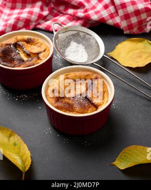 Dessert au fromage cottage cuit dans des assiettes rondes en céramique sur une table noire en bois, vue sur le dessus Banque D'Images