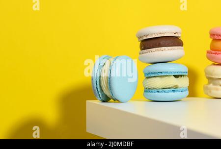 Macarons ronds cuits sur fond jaune, délicieux dessert Banque D'Images