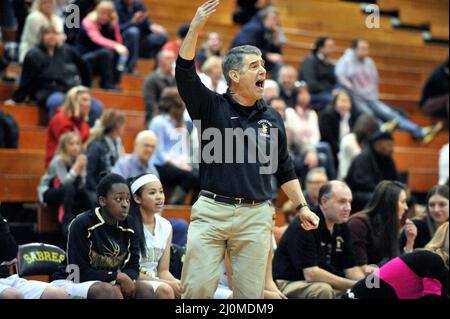 ÉTATS-UNIS. Un entraîneur de basket-ball de lycée hurle à un fonctionnaire en réaction à un appel sur le terrain. Banque D'Images