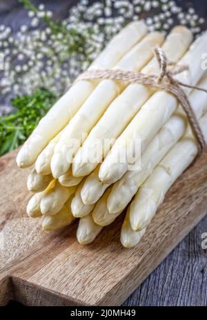 Asparagus blanc brut comme bouquet sur un vieux panneau rustique en bois comme gros plan Banque D'Images