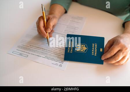 PESEL. Numéro d'identification national en Pologne. ID polonais. Document personnel officiel.femme écrire à la main avec un stylo dans le document PESEL sur table blanche Banque D'Images