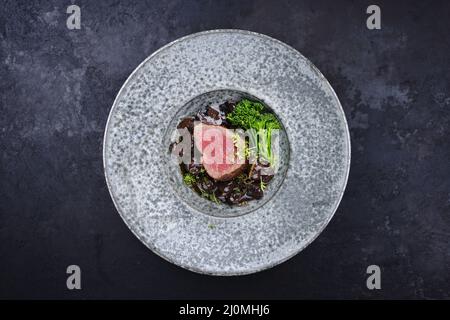 Style moderne traditionnel frit et sec filet de bœuf angus medaillons naturels aux champignons et au brocoli en sauce au vin rouge Banque D'Images
