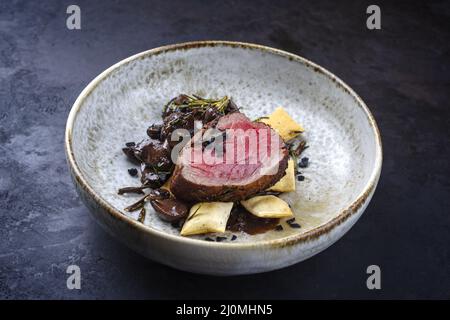 Style moderne traditionnel frit et sec filet de bœuf angus medaillons naturels aux champignons et casse-croûte dans une sauce au vin rouge Banque D'Images
