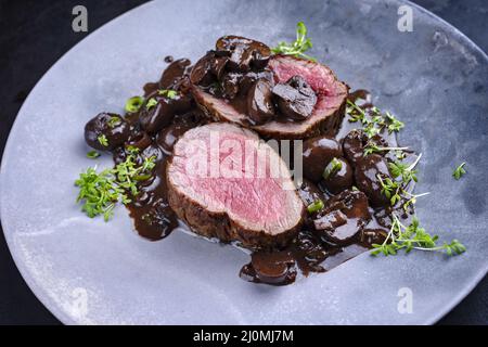 Des filets de bœuf angus frits et séchés, de style moderne, naturels aux champignons et à la sauce au vin rouge servis en gros plan Banque D'Images