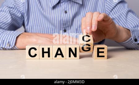 Faire basculer le cube avec le mot chance de changer. Homme assis à la table avec des cubes en bois. Développement personnel, développement de carrière, succès, concept de pensée positive. Photo de haute qualité Banque D'Images