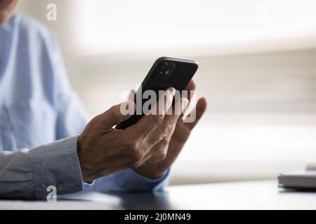 Gros plan des mains de femmes plus âgées tenant le smartphone Banque D'Images