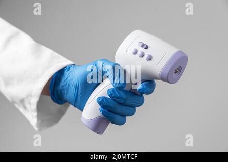 Médecin avec gants tenant le thermomètre Banque D'Images