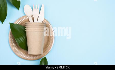 Assiettes jetables avec tasses couverts bleu espace copie arrière-plan Banque D'Images