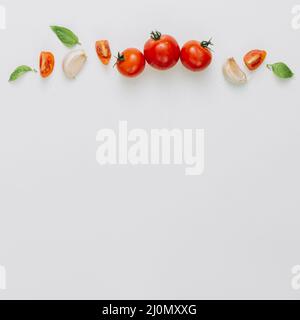 (1) tranche entière tomates cerises ail gousse basilic fond blanc Banque D'Images