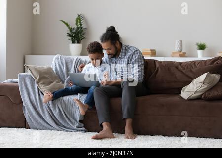 Un père africain qui aide un enfant à faire ses devoirs à la maison Banque D'Images