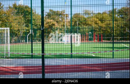 Ruban d'interdiction rouge et blanc sur la clôture du complexe sportif. Fermé pour visite, quarantaine Banque D'Images