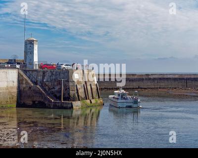 La Serenity II une embarcation de plaisance emportant des gens sur des voyages aux îles Farne venant le long des murs du port à Seahouses sur Low Tide. Banque D'Images