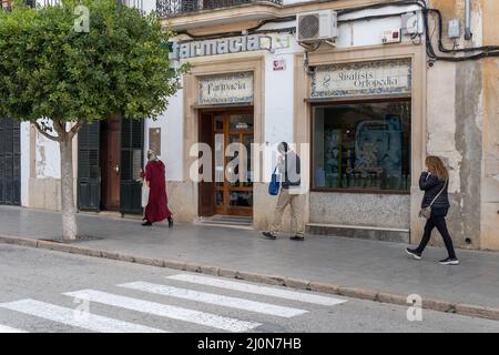 Felanitx, Espagne; mars 11 2022: Façade principale d'une ancienne pharmacie, avec des personnes marchant dans la rue. Felanitx, île de Majorque, Espagne Banque D'Images