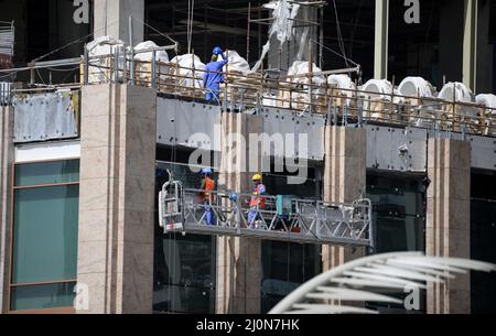 Doha, Qatar. 20th mars 2022. Les ouvriers de la construction travaillent dans un immeuble de grande hauteur dans le centre-ville de Doha. De nombreuses rues et maisons sont actuellement en cours de refonte à l'approche de la coupe du monde. Le Qatar est à maintes reprises critiqué pour son traitement des travailleurs étrangers. Le ministre allemand de l'économie et de la protection du climat, Habeck, effectue une visite de trois jours dans le golfe Persique. Credit: Bernd von Jutrczenka/dpa/Alamy Live News Banque D'Images