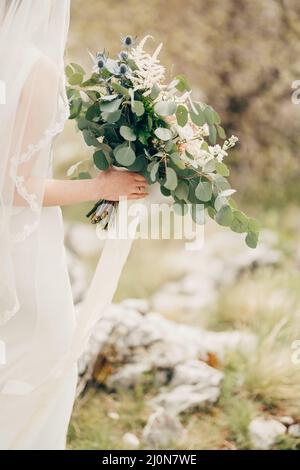 Bouquet de fleurs entre les mains de la mariée dans une robe blanche avec voile.Gros plan Banque D'Images