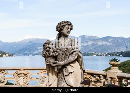 Sculpture d'une femme avec panier de fruits sur le balcon.Como, Villa Balbianello, Italie Banque D'Images