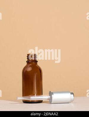 Flacon en verre brun avec supports pour pipettes sur une table blanche.Marque de cosmétiques SPA.Emballage pour gel, sérum, publicité et produ Banque D'Images