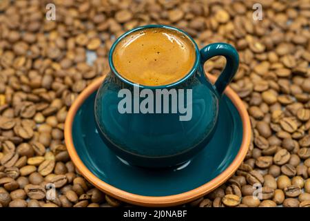 Café turc dans une tasse rustique. Arrière-plan des grains de café. Gros plan Banque D'Images