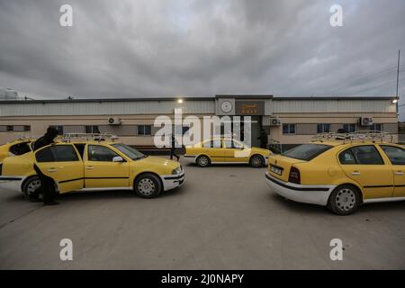 Beit Hanoun, Territoires palestiniens. 20th mars 2022. Des taxis attendent devant le passage à niveau d'Erez tandis que les travailleurs palestiniens quittent Beit Hanoun, dans le nord de la bande de Gaza, pour aller travailler en Israël. Israël se prépare à délivrer 2 000 permis de travail aux Palestiniens vivant à Gaza, ce qui porte à 12 000 le nombre total de travailleurs du côté israélien. Credit: Mohammed Talatene/dpa/Alay Live News Banque D'Images