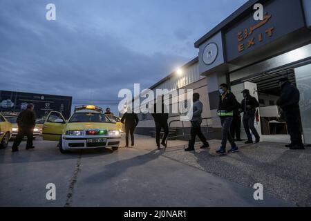 Beit Hanoun, Territoires palestiniens. 20th mars 2022. Les travailleurs palestiniens marchent à l'extérieur du passage à niveau d'Erez alors qu'ils quittent Beit Hanoun dans le nord de la bande de Gaza, pour aller travailler à l'intérieur d'Israël. Israël se prépare à délivrer 2 000 permis de travail aux Palestiniens vivant à Gaza, ce qui porte à 12 000 le nombre total de travailleurs du côté israélien. Credit: Mohammed Talatene/dpa/Alay Live News Banque D'Images