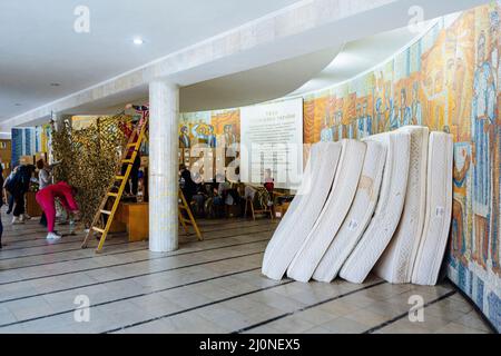 Non exclusif: UZHHOROD, UKRAINE - 12 MARS 2022 - les femmes serpentent des filets de camouflage à l'un des points d'accueil et de tri de l'aide humanitaire, Uzhho Banque D'Images