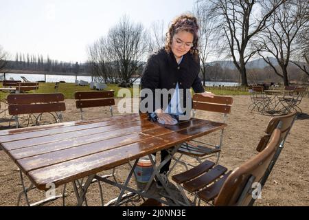 20 mars 2022, Thuringe, Ilmenau: Ashley Quednau, employé de la "Haus am See", prépare les tables dans le café en plein air pour les invités. De nombreuses personnes apprécient le temps et le soleil printaniers de la Thuringe. Photo: Michael Reichel/dpa-Zentralbild/dpa Banque D'Images