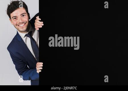 Un jeune homme d'affaires souriant se papas de l'écriteau noir. Haute qualité et résolution magnifique concept de photo Banque D'Images