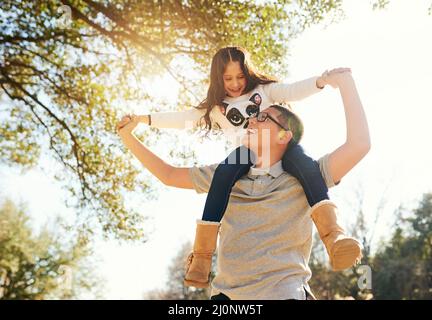 S'amuser avec ma sœur. Photo sous angle d'un adolescent portant son adorable petit frère sur ses épaules à l'extérieur. Banque D'Images