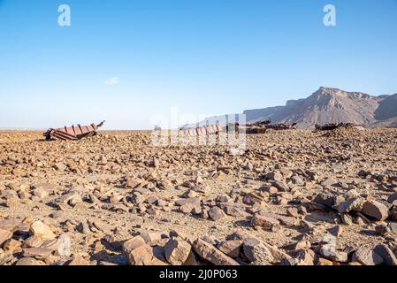 Wagons endommagés sur le sol rocheux près du tunnel de Choum du chemin de fer mauritanien, Mauritanie Banque D'Images