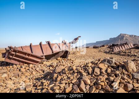 Wagons endommagés sur le sol rocheux près du tunnel de Choum du chemin de fer mauritanien, Mauritanie Banque D'Images