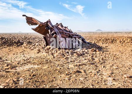 Wagons endommagés sur le sol rocheux près du tunnel de Choum du chemin de fer mauritanien, Mauritanie Banque D'Images