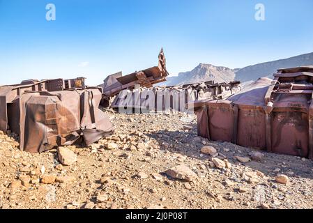 Wagons endommagés sur le sol rocheux près du tunnel de Choum du chemin de fer mauritanien, Mauritanie Banque D'Images