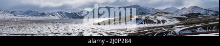 Changement de saison dans les hauts plateaux islandais. Montagnes colorées de Landmannalaugar sous la neige en automne. Lac Frostastastadavatn a Banque D'Images