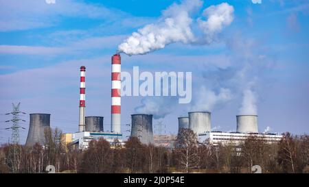 Vue lointaine d'une centrale au charbon. Cheminées à fumée et vapeur provenant des tours de refroidissement. Photo prise par temps ensoleillé, éclairage contrasté. Banque D'Images