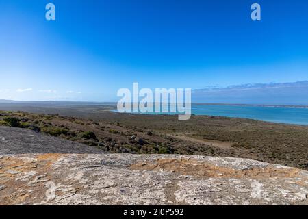 Focus sélectif eaux bleu turquoise de la lagune de Langebaan dans le parc national de la côte ouest en Afrique du Sud. Grand rocher de granit au premier plan Banque D'Images