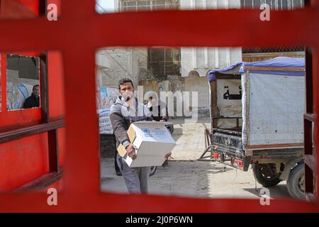 Gaza. 20th mars 2022. Un réfugié reçoit de la nourriture d'un centre de distribution de l'Office de secours et de travaux des Nations Unies pour les réfugiés de Palestine dans le proche-Orient (UNRWA) situé dans le camp de réfugiés d'Al-Shati à Gaza, le 20 mars 2022. Credit: Rizek Abdeljawad/Xinhua/Alamy Live News Banque D'Images